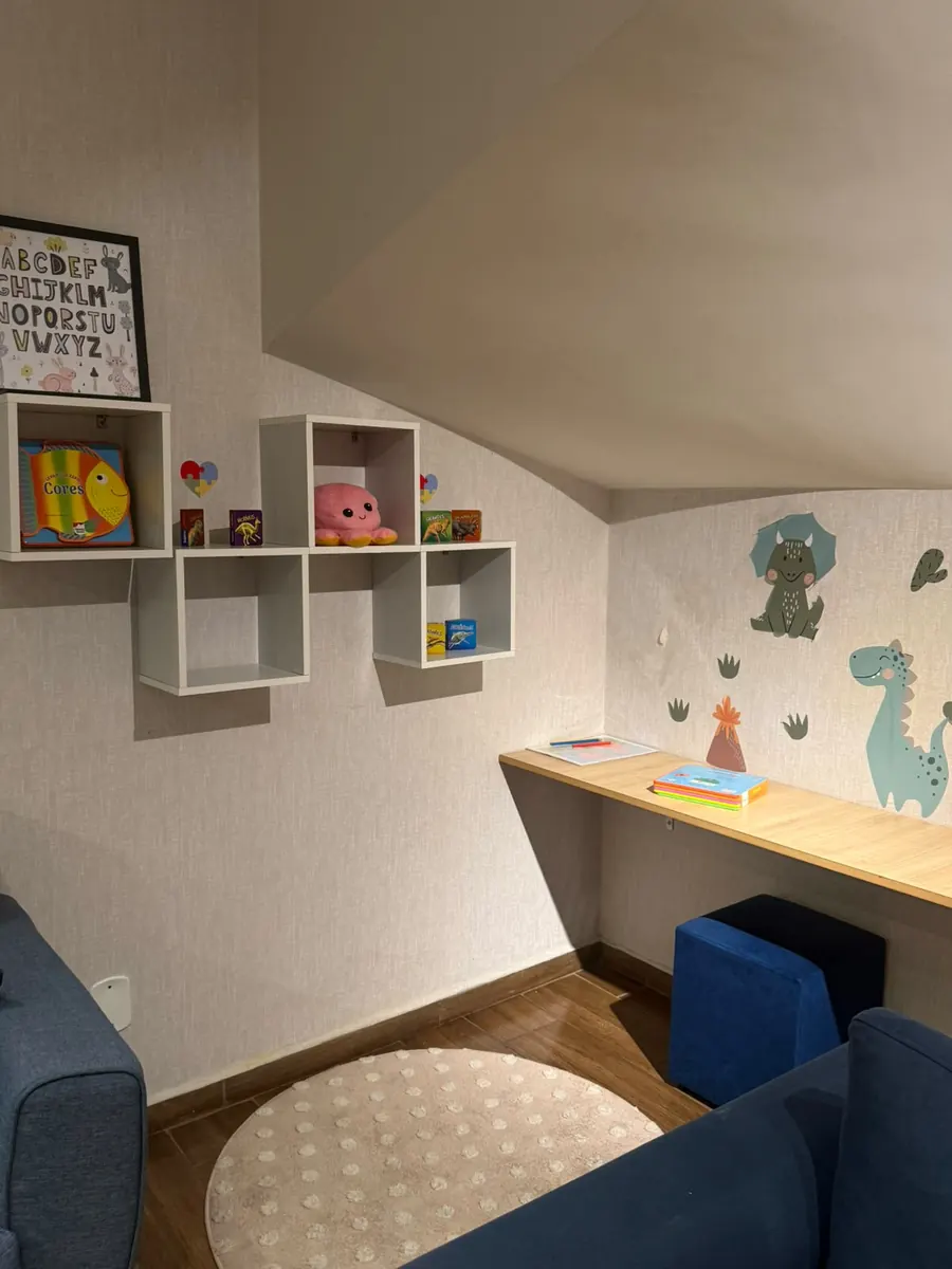 Cantinho de leitura com prateleiras e decoração de dinossauros