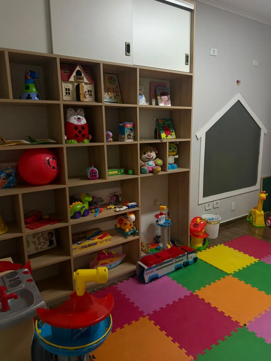 Sala de brinquedos com estante ampla e tapete colorido