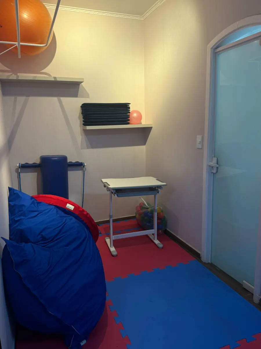 Sala de terapia com puff, mesinha e bola suíça