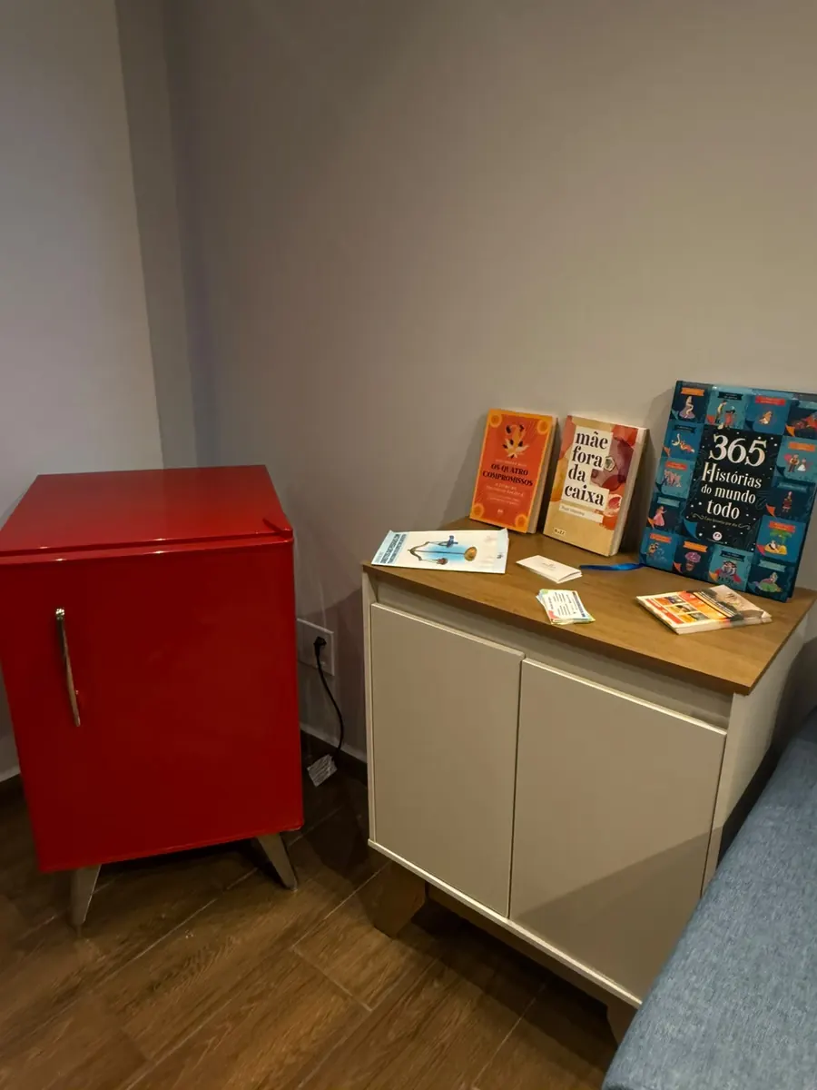 Consultório com mesa de atendimento e biblioteca